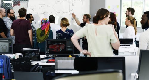 Warum macht man eine Umschulung? Eine Gruppe junger Menschen, die gemeinsam an einem Projekt arbeiten.