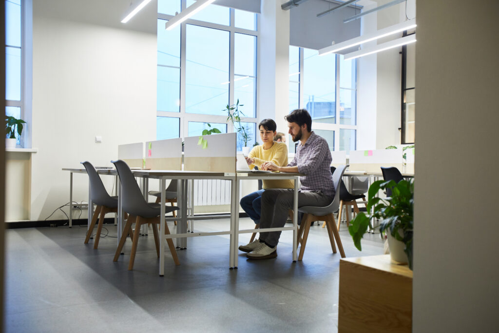 Zwei Leute sitzen am Schreibtisch und arbeiten am SEO Marketing