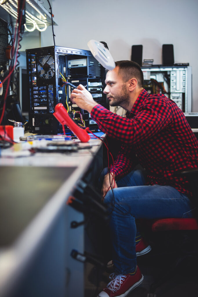 Ein IT Fachinformatiker, während er einen Computer repariert.