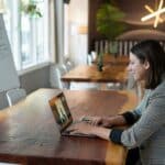 Frau sitzt für einen Videocall am Laptop
