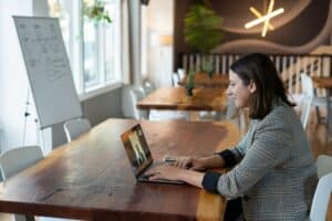 Frau sitzt für einen Videocall am Laptop