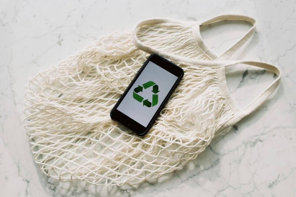 Stoffbeutel und Smartphone mit einem Recycle-Zeichen