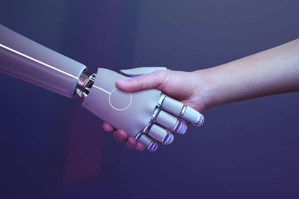 Eine menschliche Hand und eine Roboterhand schütteln sich die Hände zur Begrüßung.