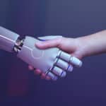 Eine menschliche Hand und eine Roboterhand schütteln sich die Hände zur Begrüßung.