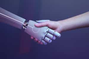 Eine menschliche Hand und eine Roboterhand schütteln sich die Hände zur Begrüßung.