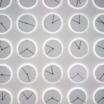 Analog Uhren mit unterschiedlichen Uhrzeiten aneinander gereiht.