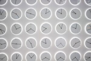 Analog Uhren mit unterschiedlichen Uhrzeiten aneinander gereiht.